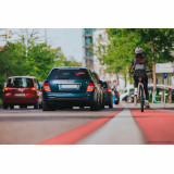 Eine Frau fährt auf einem gut ausgebauten radweg in der Stadt.